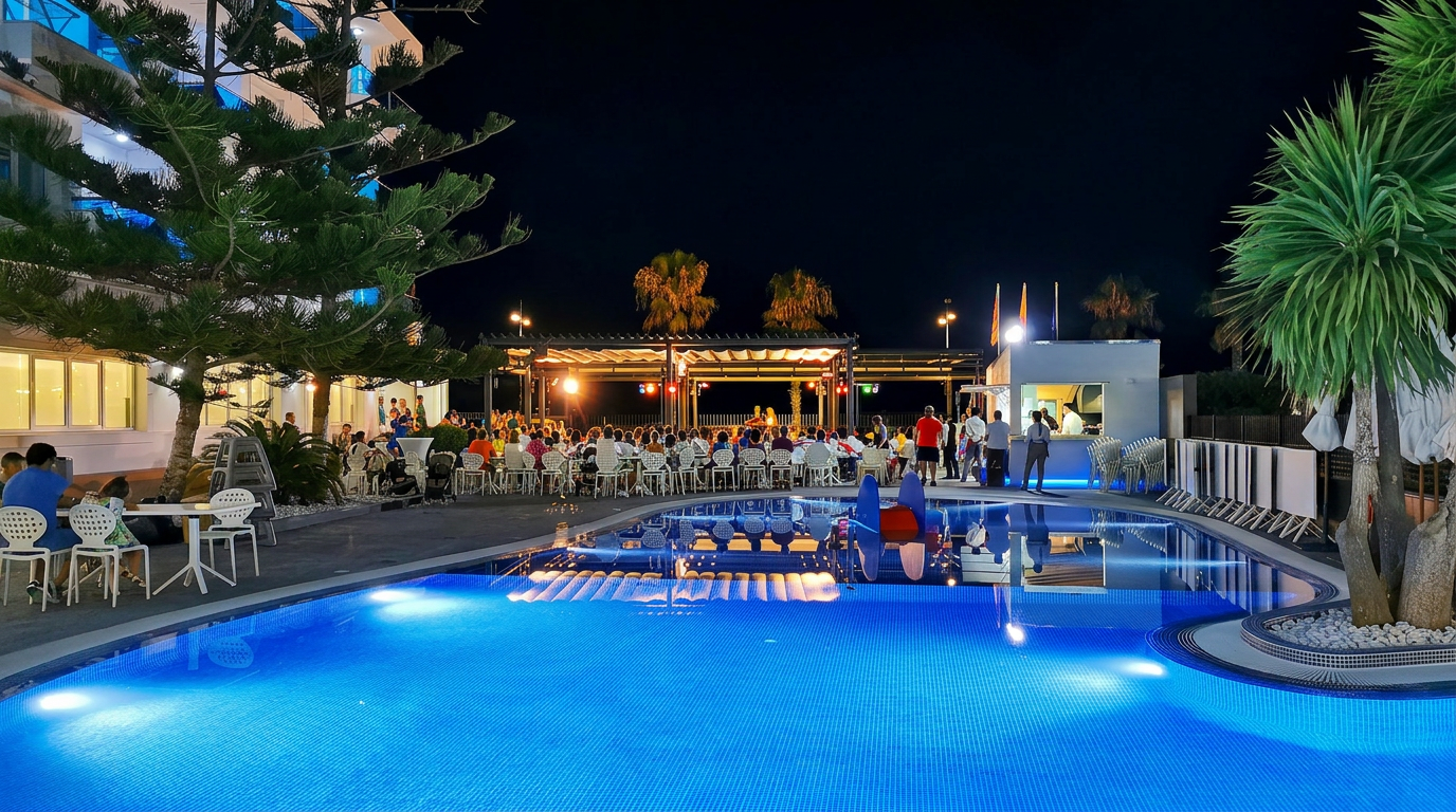 Piscina exterior iluminada del Hotel Acuazul en Peñíscola durante un espectáculo nocturno