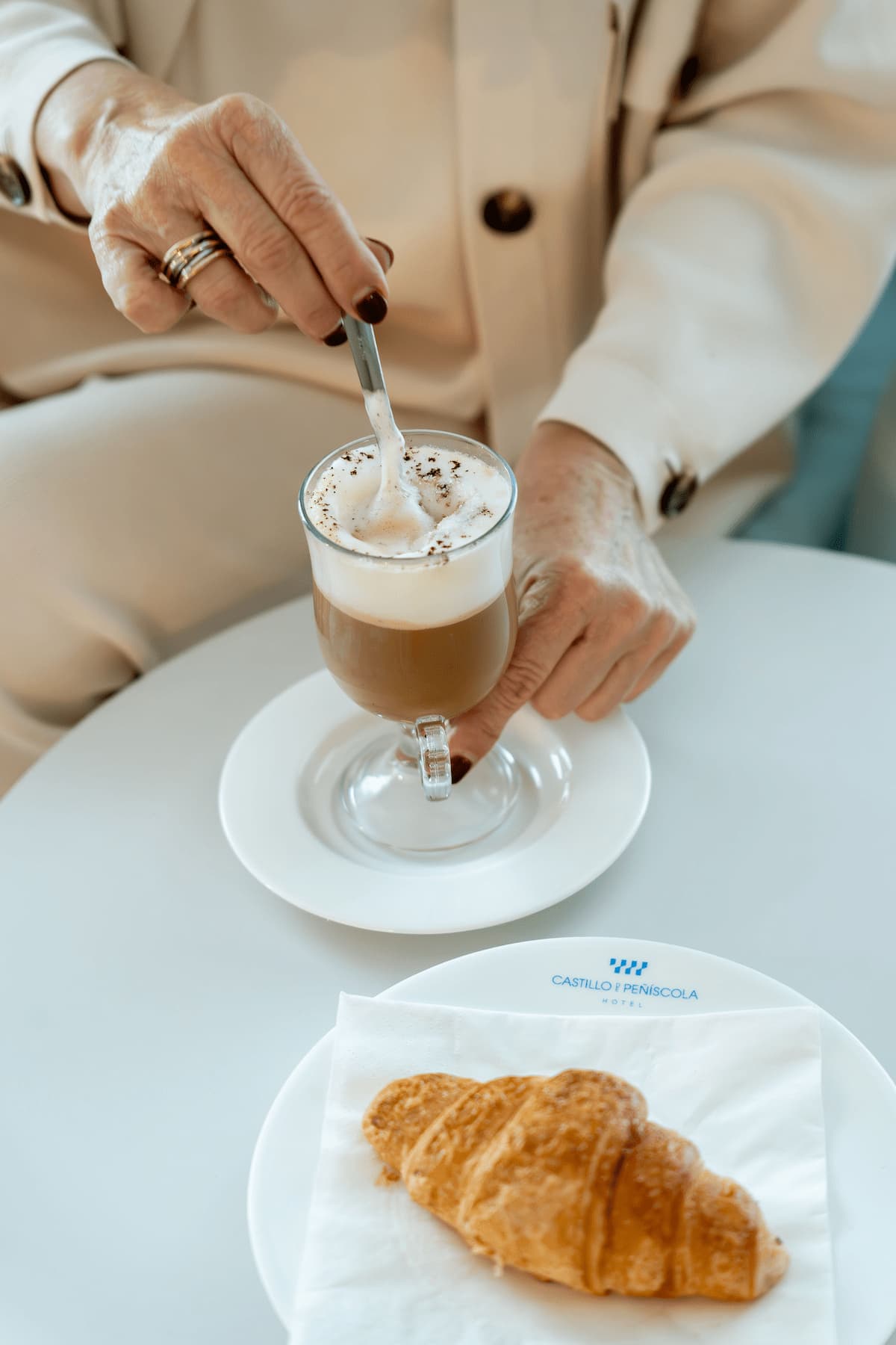 Desayuno con café con leche y croissant en la terraza de la cafetería con vistas al castillo