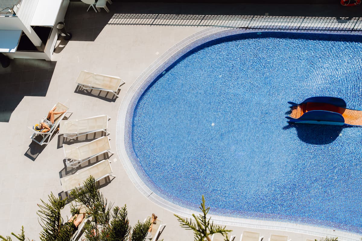 Vista cenital de la piscina con toboganes infantiles y zona de solárium del Hotel Acuazul Peñíscola 4 estrellas