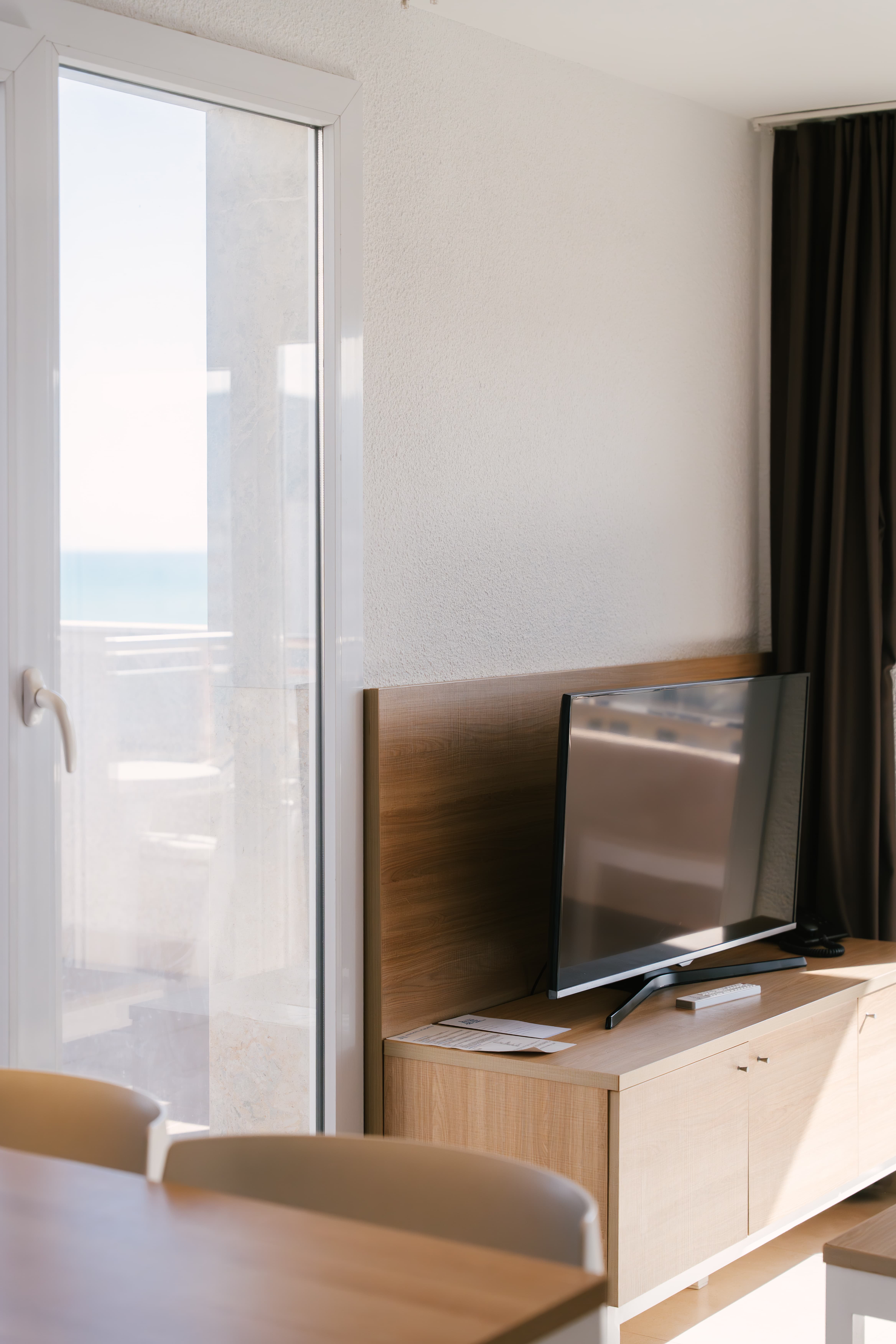 Salón del apartamento del Aparthotel Acualandia Peñíscola con televisión y balcón al mar