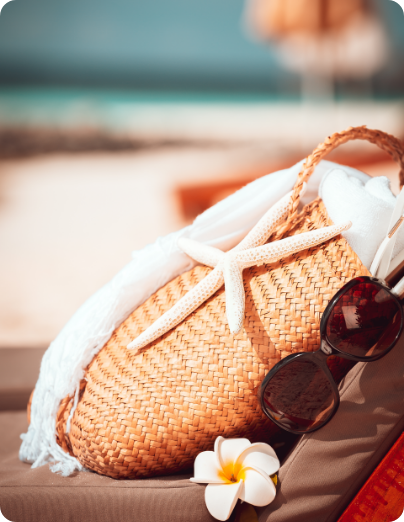 Bolso de rafia, gafas de sol y tumbona en la playa de Peñíscola, ambiente de vacaciones estivales en el Mediterráneo