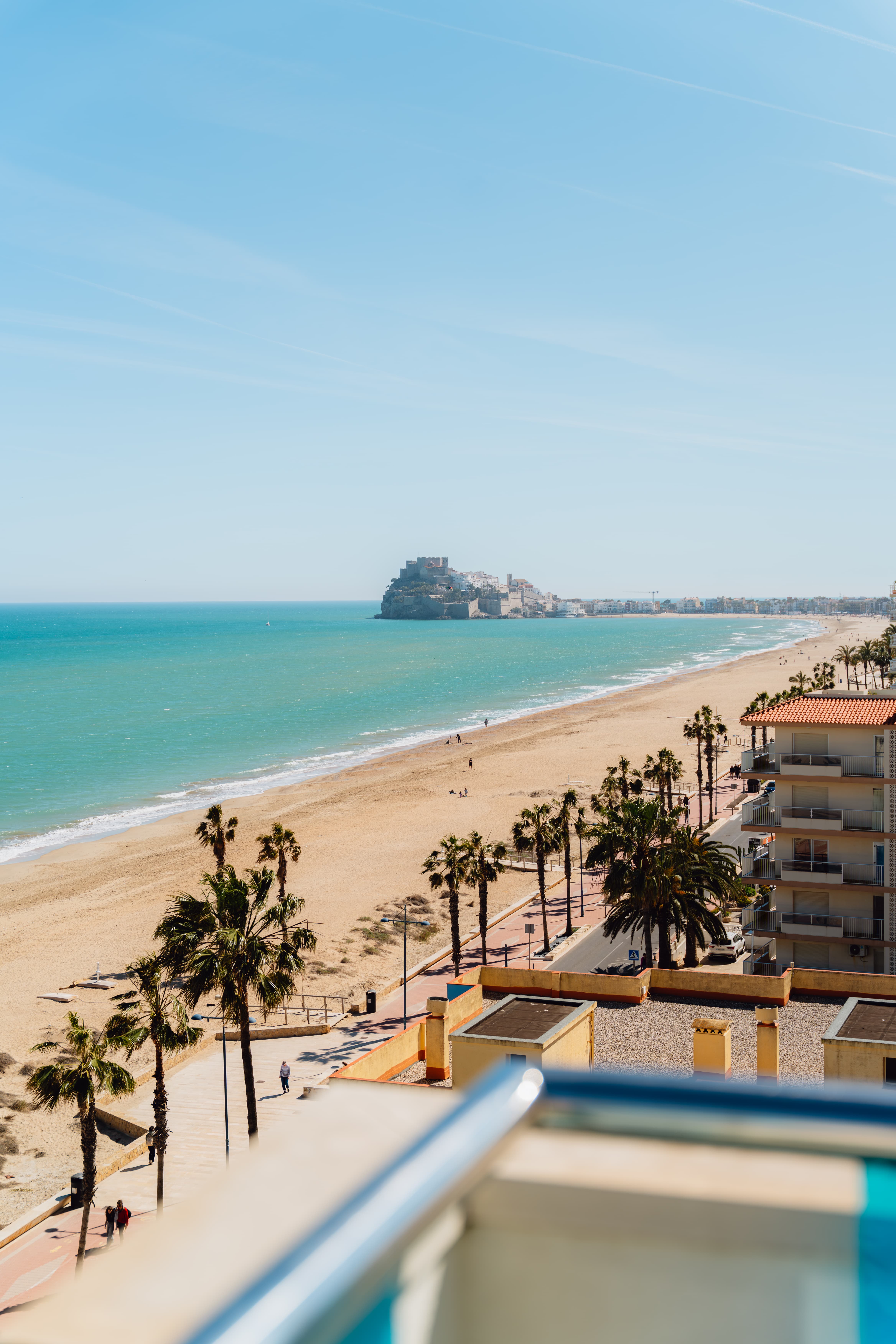 Vista desde el balcón de Hoteles Mediterráneo con la playa de Peñíscola, el paseo marítimo con palmeras y el Castillo del Papa Luna al fondo